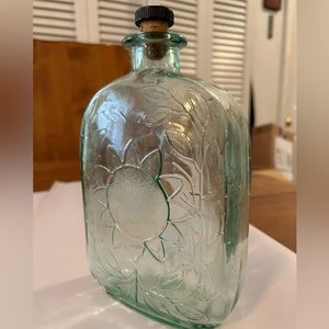 8.5”H Green Glass sunflower bottle with cork top.